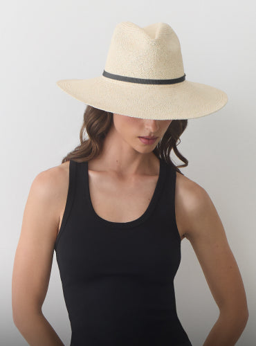 Person wearing a wide-brimmed hat and sleeveless top.