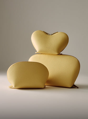 Three textured pouches of different shapes and sizes stacked together.