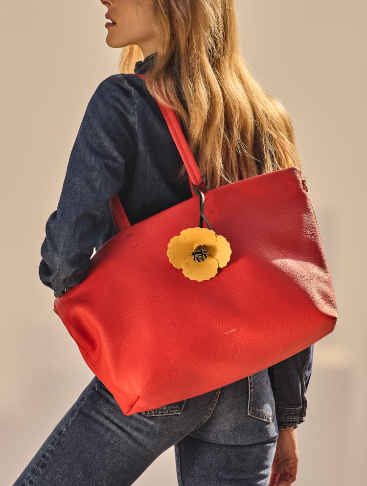Person carrying large shoulder bag with flower detail