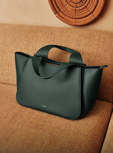 Handbag on a couch with circular wall decor in the background