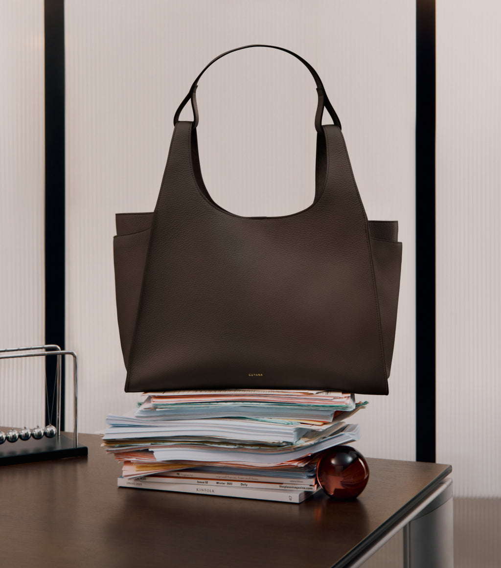 Large bag on stacked papers on a desk