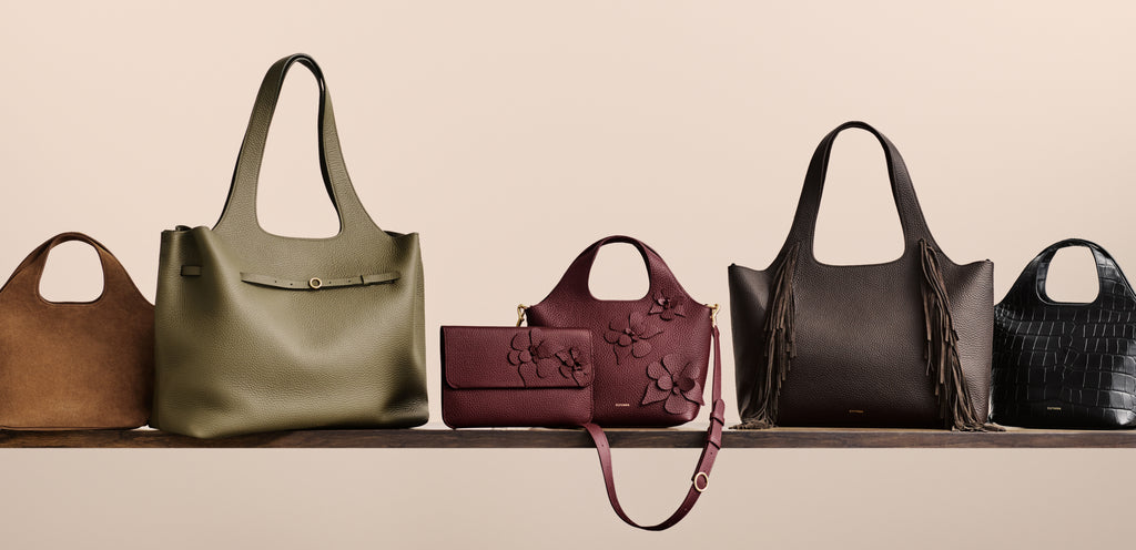 Various handbags and a wallet displayed on a shelf.