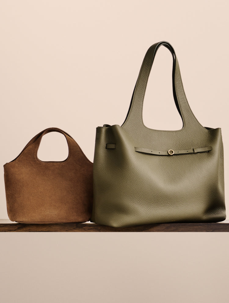 Two handbags on a wooden surface.
