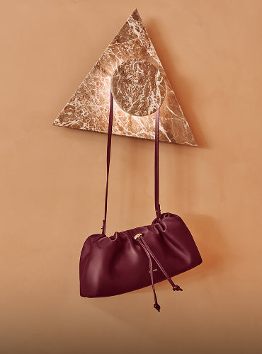 Purse hanging on a wall hook with a marble triangle design.