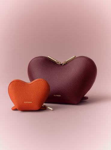 Two heart-shaped leather pouches, one larger and one smaller, with zippers.