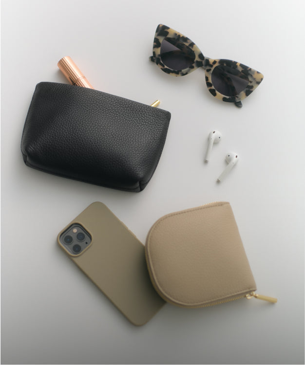 Items include sunglasses, earbuds, phone case, a small purse, and a pouch with a lipstick.