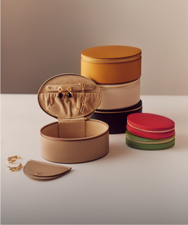 Stacked round jewelry cases and accessories on display.