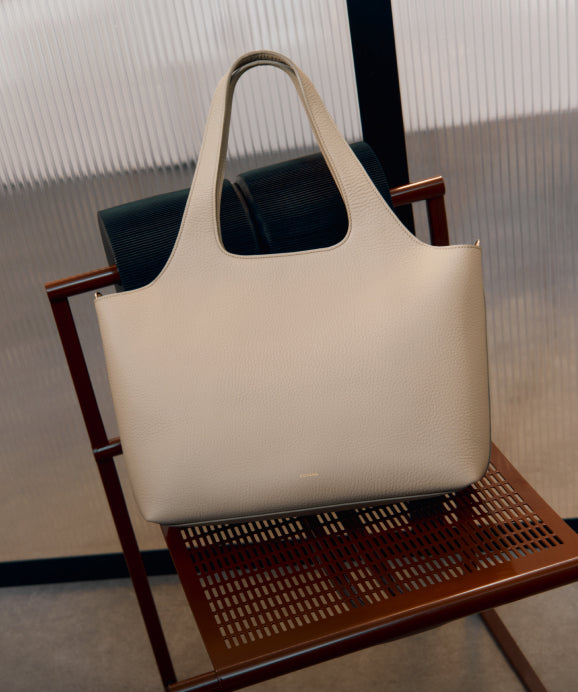 Linked Image: Directs to Work Bags shop page. Image Description: The Cuyana System Tote in color Stone.