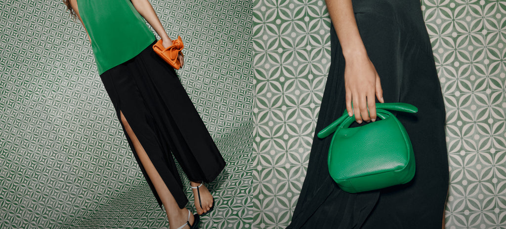 Left: Model in green top and black pants holds orange clutch. Right: Model in black holds green purse.
