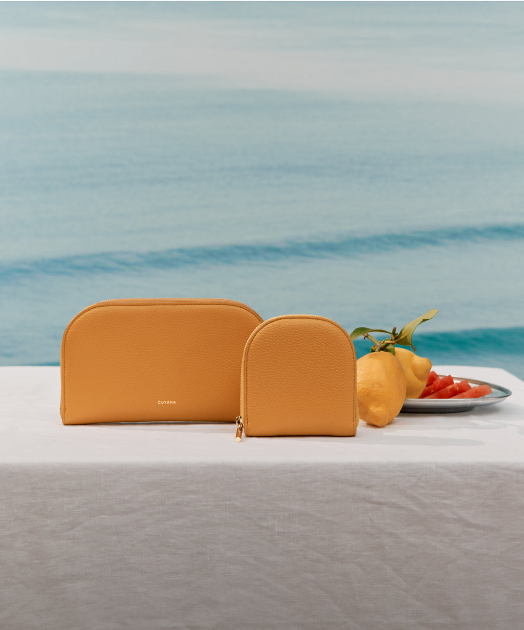 Orange wallet and small orange wallet next to plate of lemons. Linked Image