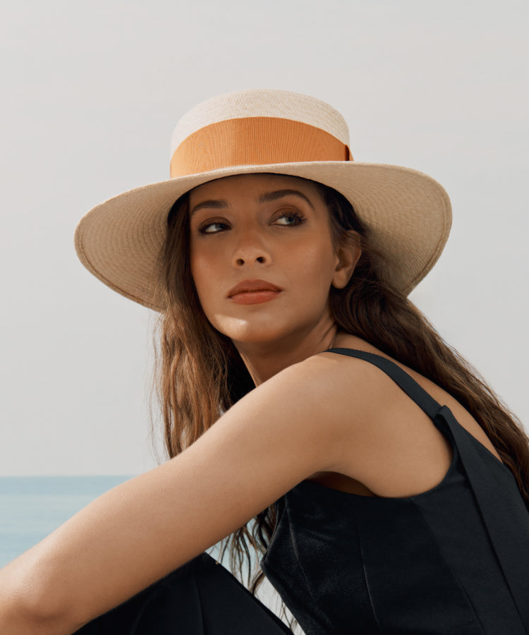 Woman in a wide-brimmed hat looking over her shoulder.