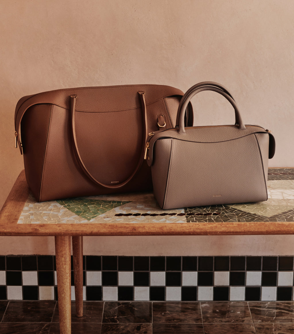 Two handbags on a patterned table.