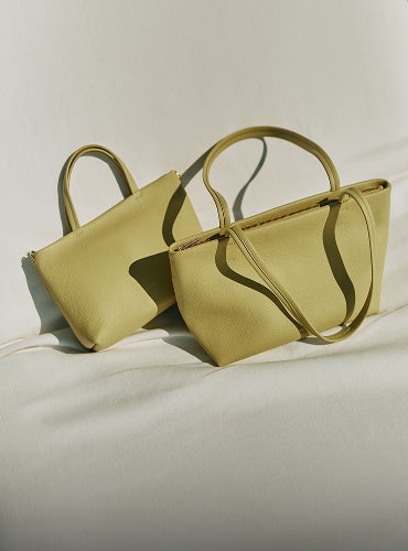 Two handbags with short handles on a plain background.