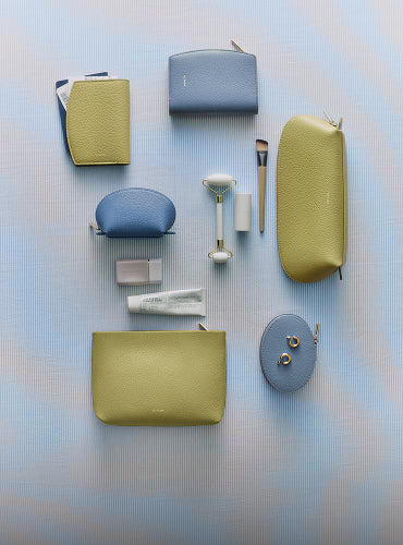 Various cosmetic bags and beauty tools arranged on a flat surface.