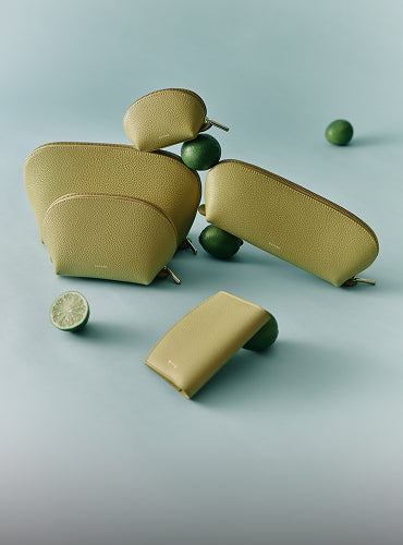 Five pouches arranged with limes on a light surface.