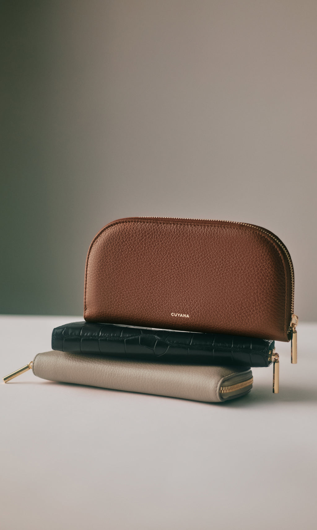 Three leather pouches stacked on a surface