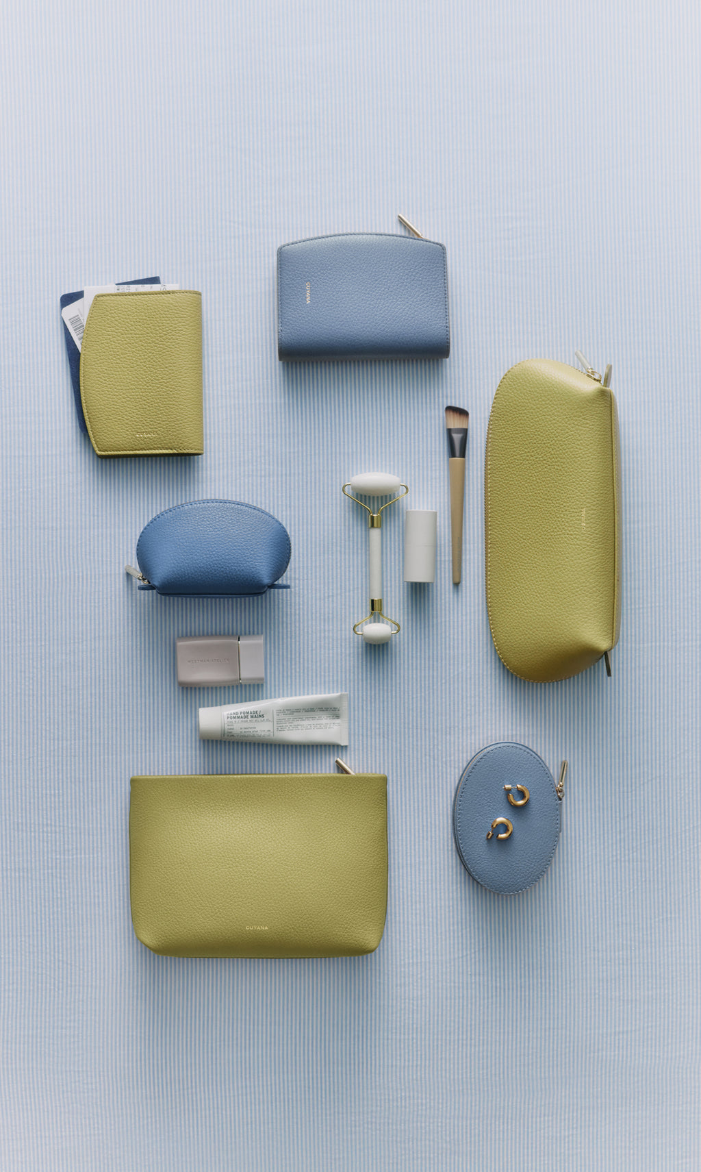 Various cosmetic bags and beauty tools arranged on a striped surface.
