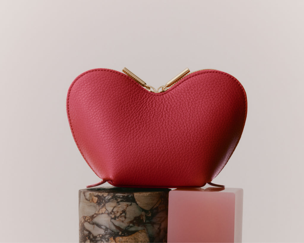 Heart-shaped purse on a marbled and solid pedestal