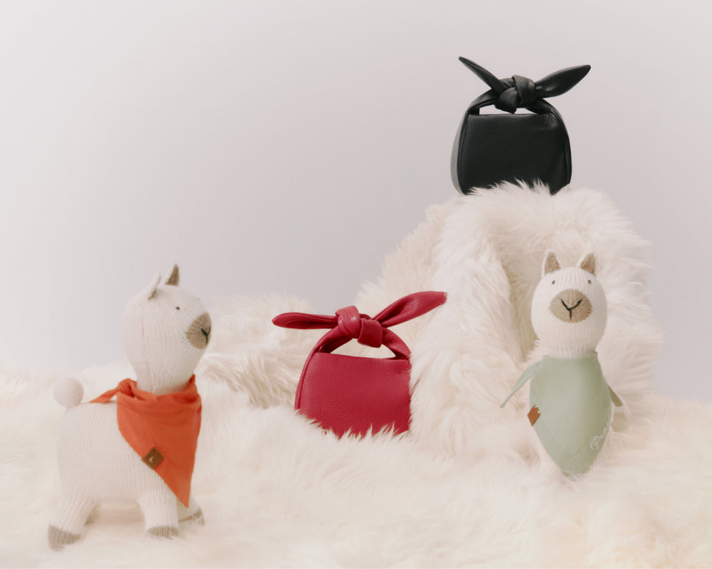 Three stuffed animals arranged in a row on a fluffy surface.