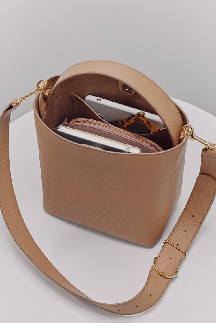 Open handbag with a smartphone, wallet, and keys inside.