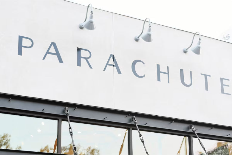 Exterior of a building with the word Parachute and hanging lights above.