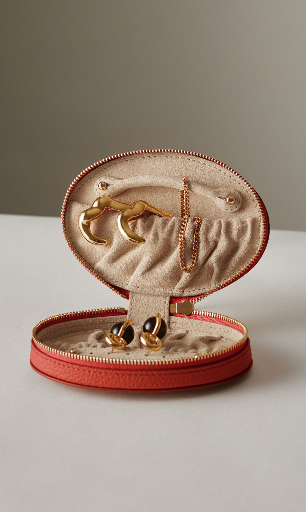Jewelry case open displaying earrings and necklace inside.