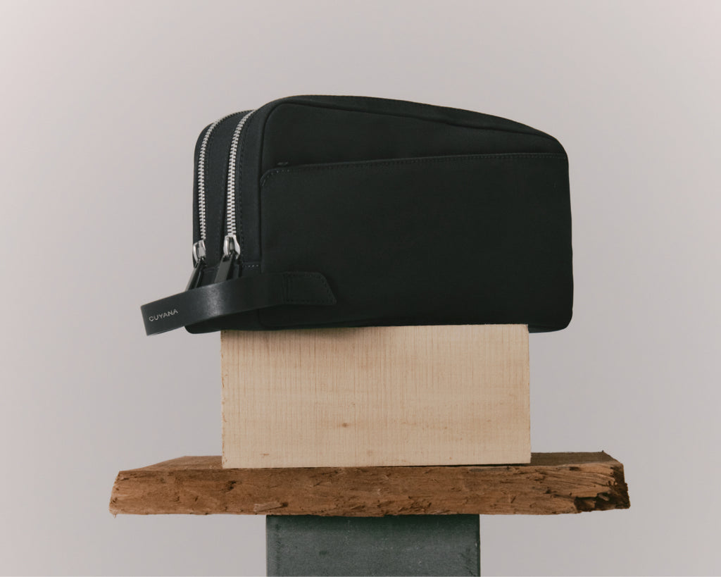 A toiletry bag sits atop two stacked wood blocks.