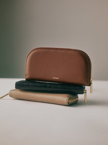 Three zippered pouches stacked on a flat surface.