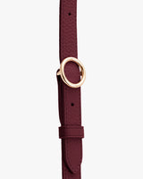 Thin belt with a round metal buckle.