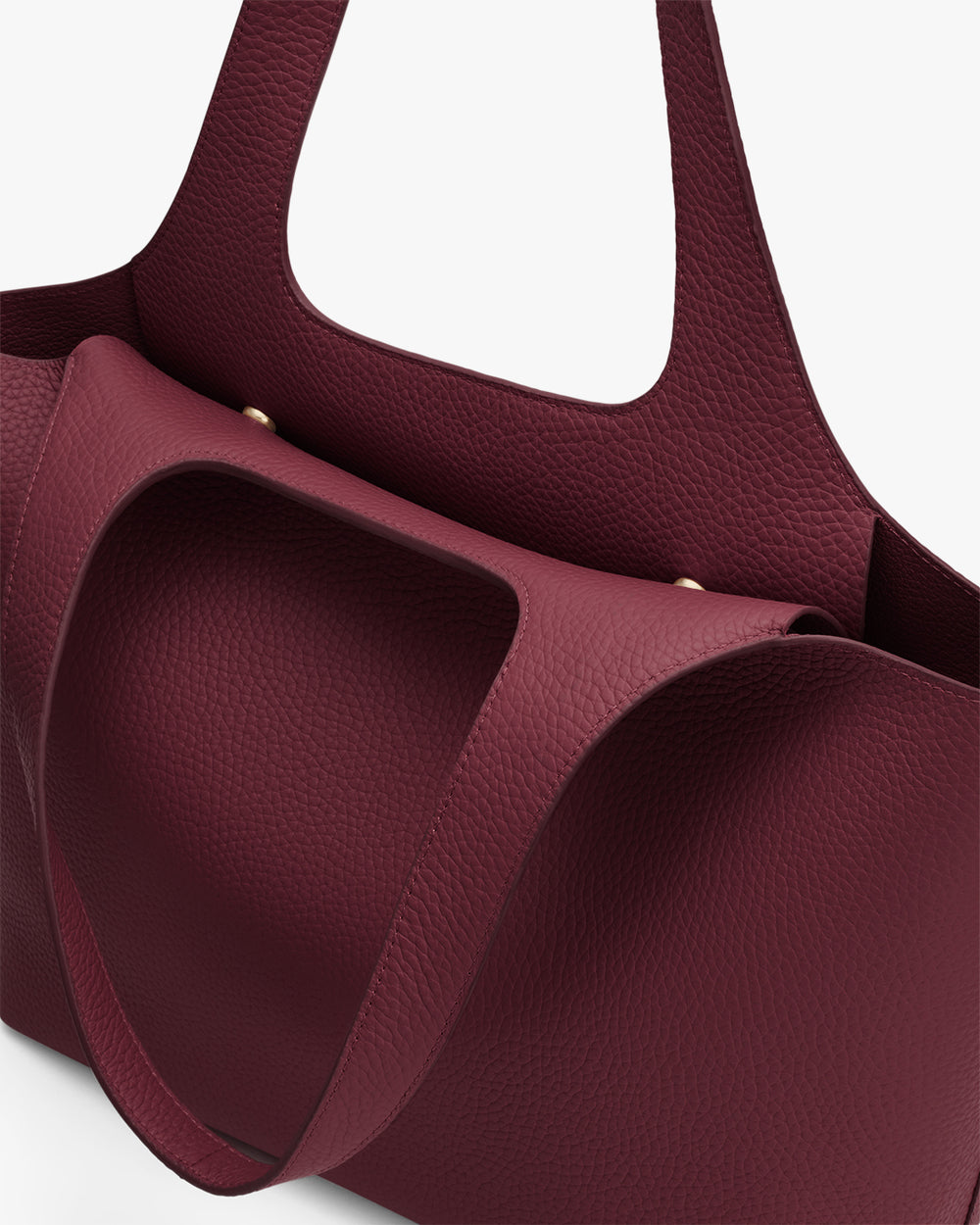 A close-up of an open tote bag with a pebbled texture and thick shoulder straps.