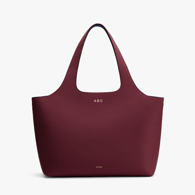 A soft textured tote bag with two long handles and minimal design.