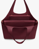 Open travel bag with multiple compartments, handles, and interior pockets.