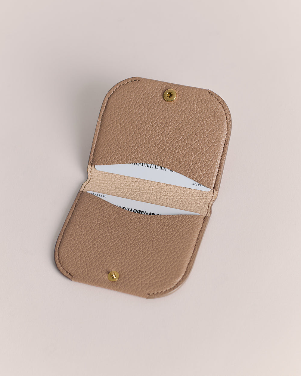 Cardholder with rounded corners and snap button closure.