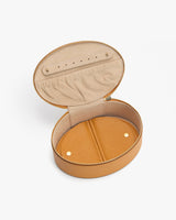 Open jewelry case with a round shape and zipper closure.