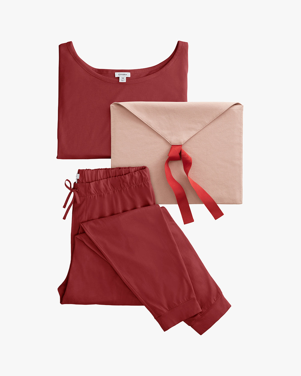 Folded shirt and drawstring pants next to a large envelope-shaped package.