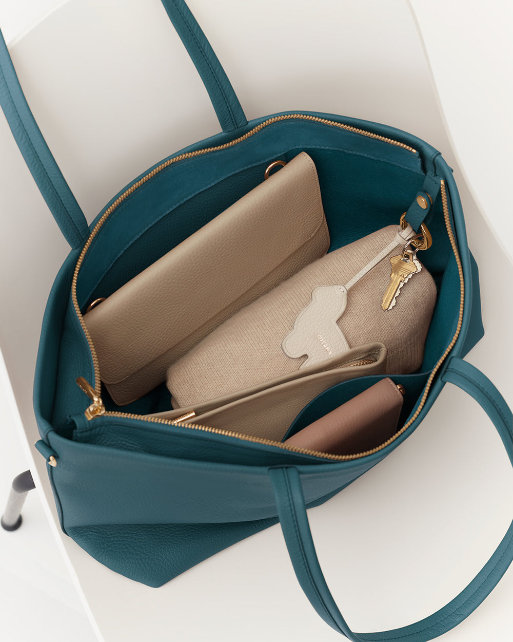 Open tote bag with a wallet, pouch, and keys inside.