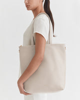 Person holding a large tote bag over their shoulder