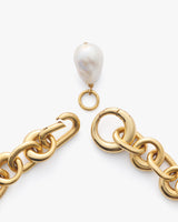 Gold chain necklace with a hanging pearl charm.