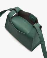 Open handbag with long strap and magnetic closure.