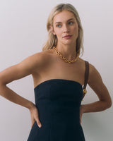 Person wearing a strapless dress and chain necklace