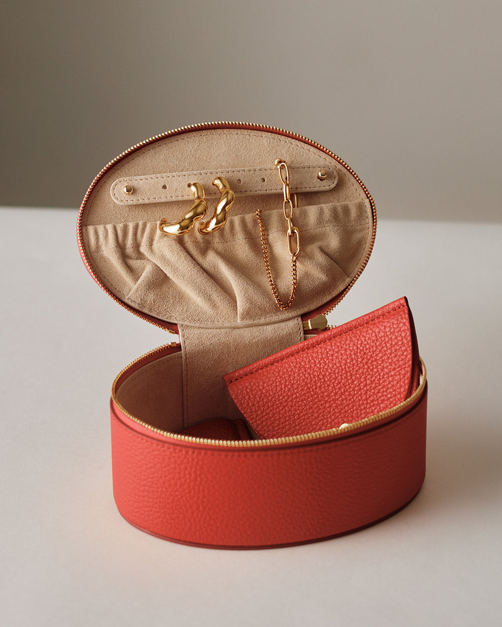Open jewelry case with earrings, necklace, and a small pouch inside.