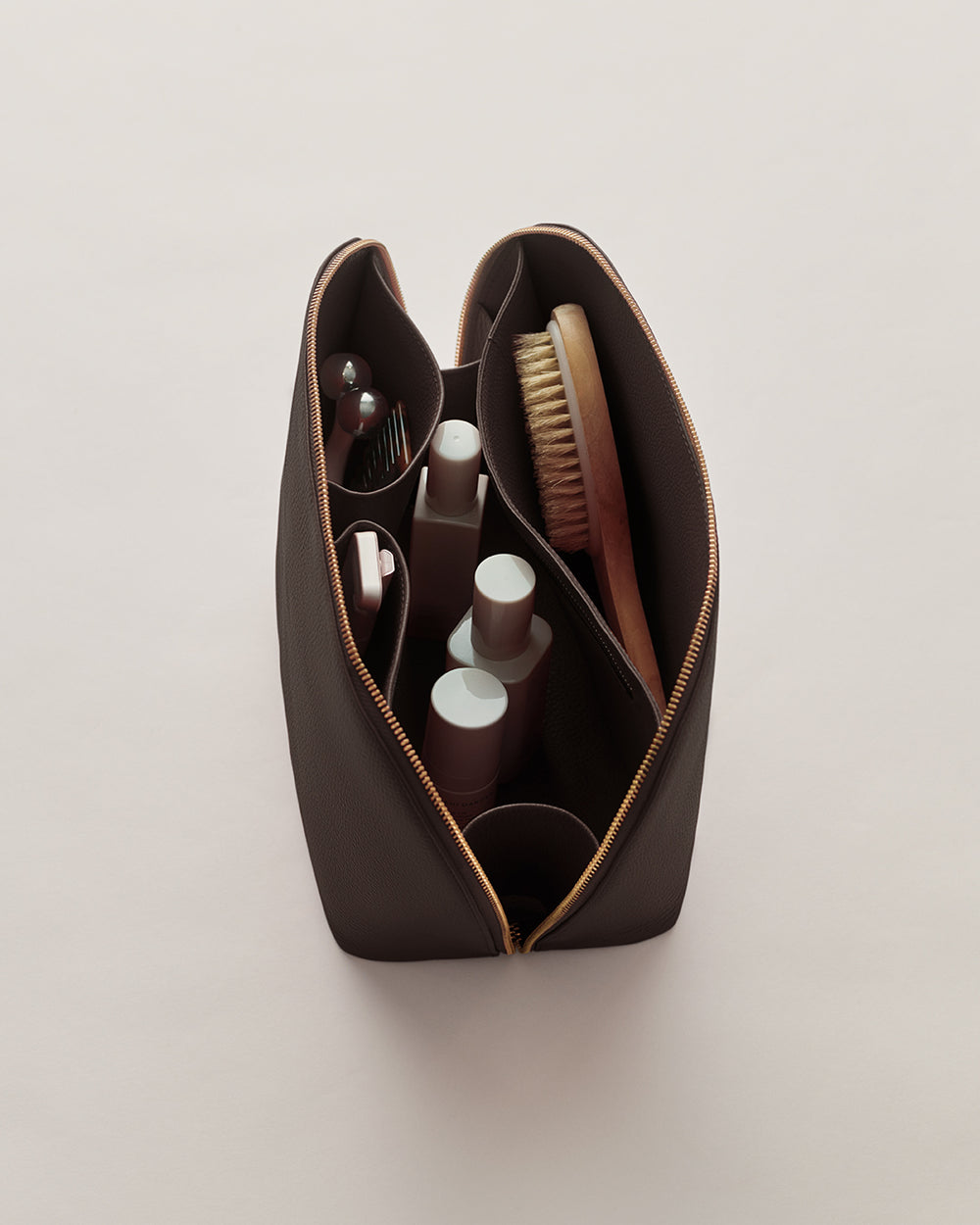 Open toiletry bag with bottles and brush inside.