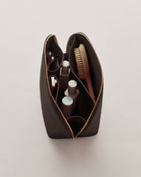 Open toiletry bag with bottles and brush inside.