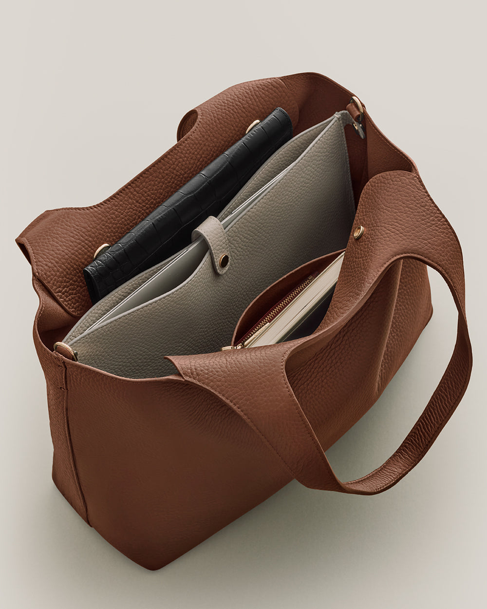 Open tote bag with pouches and a book inside