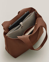 Open tote bag with pouches and a book inside