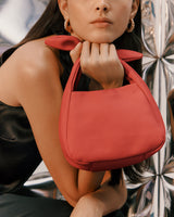 Person holding a handbag with shiny background.