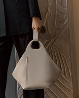Person holding a handbag with a zipper detail