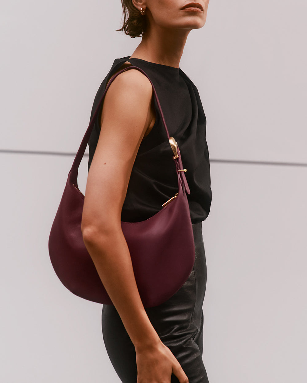 Woman holding a shoulder bag and wearing a sleeveless top