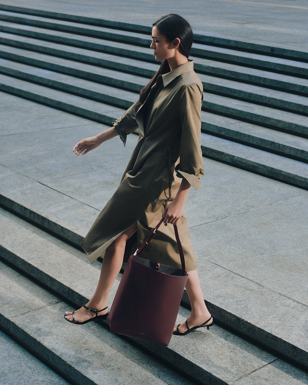 Person walking down steps carrying a tote bag.