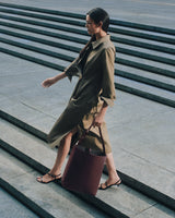 Person walking down steps carrying a tote bag.